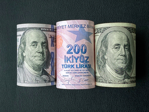 Dollar and Turkish lira rolls on a black background