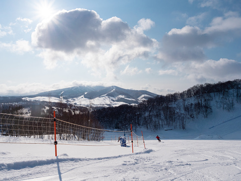 Teenage girl visiting Hokkaido in winter and enjoying snowboarding.