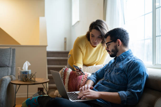 Young couple using computer at home stock photo