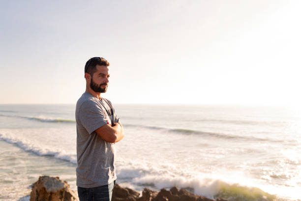 istock attractive man watching the sunset by the sea 1375442332