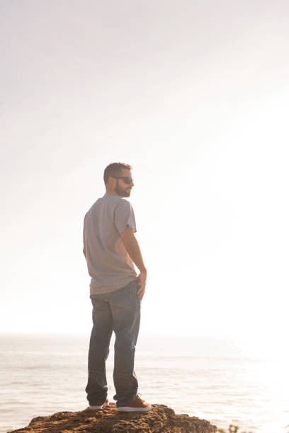 istock man with sunglasses watching the sunset by the sea 1375442333