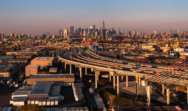 Traffic on the overpass ramp entering Kosciuszko Bridge in the industrial zone in East Williamsburg, Brooklyn, New York, with the remote view of Downtown Manhattan in the backdrop. High-resolution stitched panorama. Drone view of the industrial district in Brooklyn, with the remote view of Lower Manhattan. BQE stock pictures, royalty-free photos & images