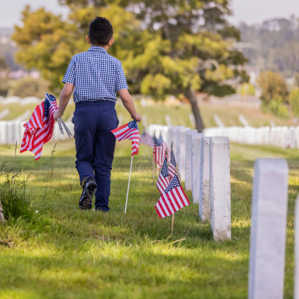 Young Boy Placing Flags on Veterans Grave