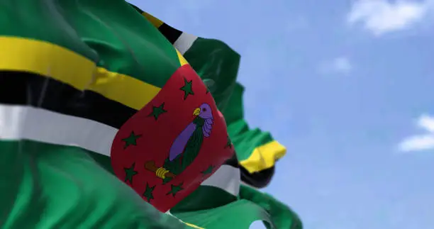 Detail of the national flag of Dominica waving in the wind on a clear day. Dominica is an island country in the Caribbean. Selective focus.