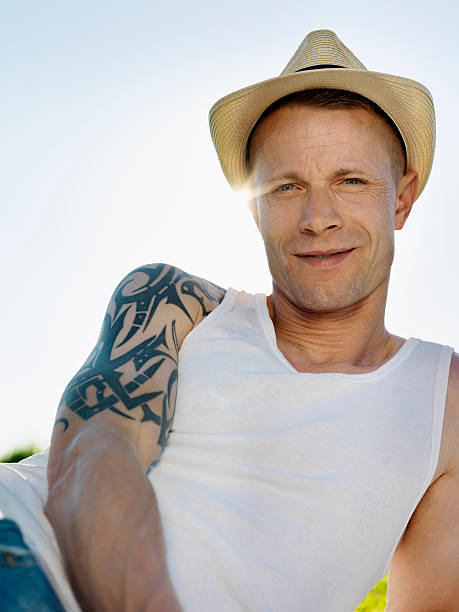 Smiling man wearing sunhat outdoors  shoulder tattoo designs for men stock pictures, royalty-free photos & images