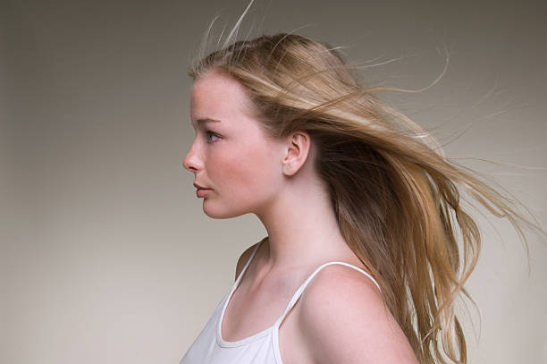 Teenage girls hair blowing in wind  15 year old blonde girl stock pictures, royalty-free photos & images