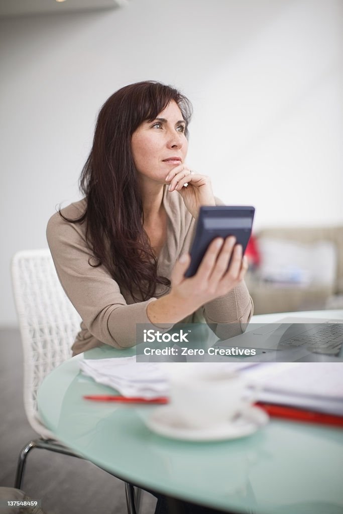 Mujer de pagar sus facturas en su hogar - Foto de stock de 40-44 años libre de derechos