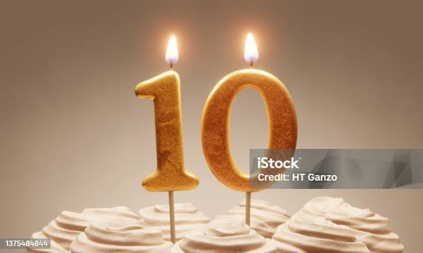 10th Birthday Or Anniversary Celebration Lit Golden Number Candles On Cake With Icing In Neutral Tones 3d Rendering Stock Photo - Download Image Now
