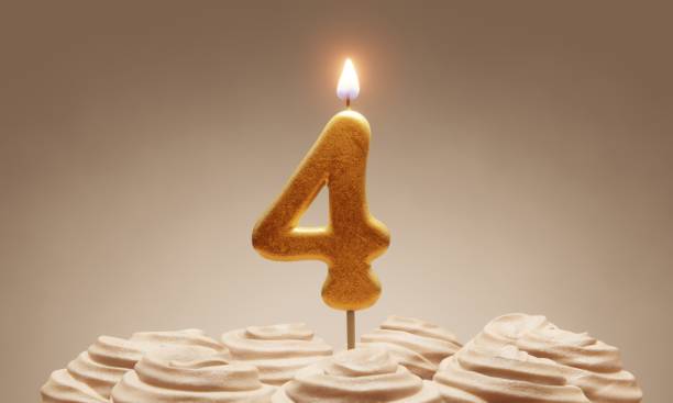 istock 4th birthday or anniversary celebration. Lit golden number candle on cake with icing in neutral tones. 3D rendering 1375485885
