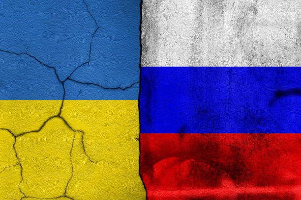 istock Broken cracked concrete wall with painted Ukraine VS Russia national flags. 1375507713