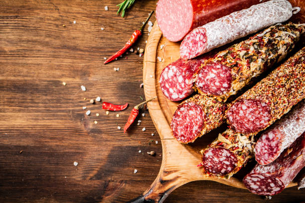 istock Different types of salami sausage on a wooden cutting board. 1375527521
