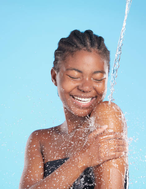 foto de una hermosa joven salpicada de agua sobre un fondo azul - human face water washing women fotografías e imágenes de stock