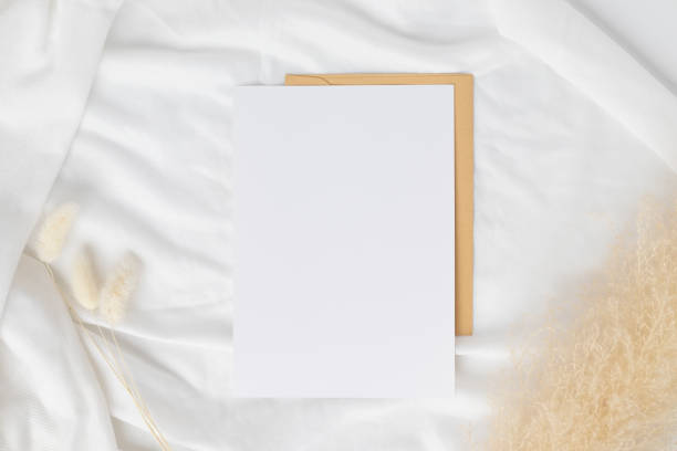 istock Blank greeting card invitation Mockup on Brown envelope with Dried bunny tails grass on white background, Minimal table workplace composition, flat lay, mockup 1375544980