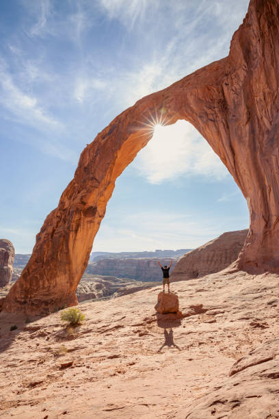 homem em pé sob um arco em moab, utah - moab utah cloud desert - fotografias e filmes do acervo