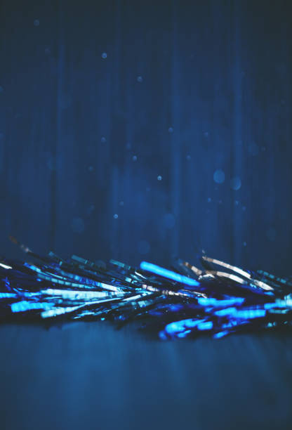 Hanukkah background with blue and silver tinsel on blue wood