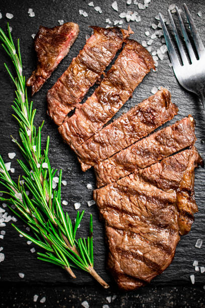 grilled steak with a sprig of rosemary. - top sirloin imagens e fotografias de stock