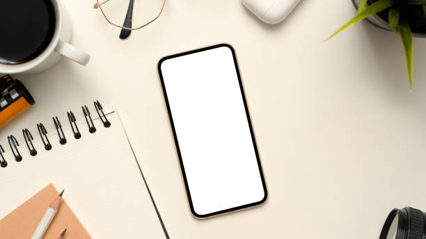 istock Minimal white office desk with smartphone mockup 1375607838