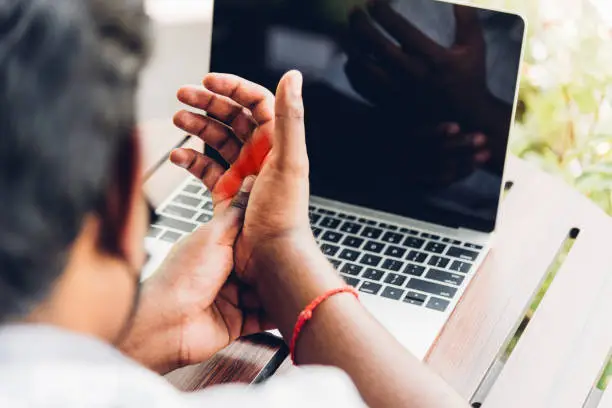 Photo of black man holding his wrist pain