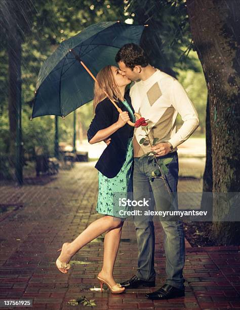 Photo Of A Couple Kissing Under A Blue Umbrella Stock Photo - Download Image Now - Beauty, Couple - Relationship, Kissing