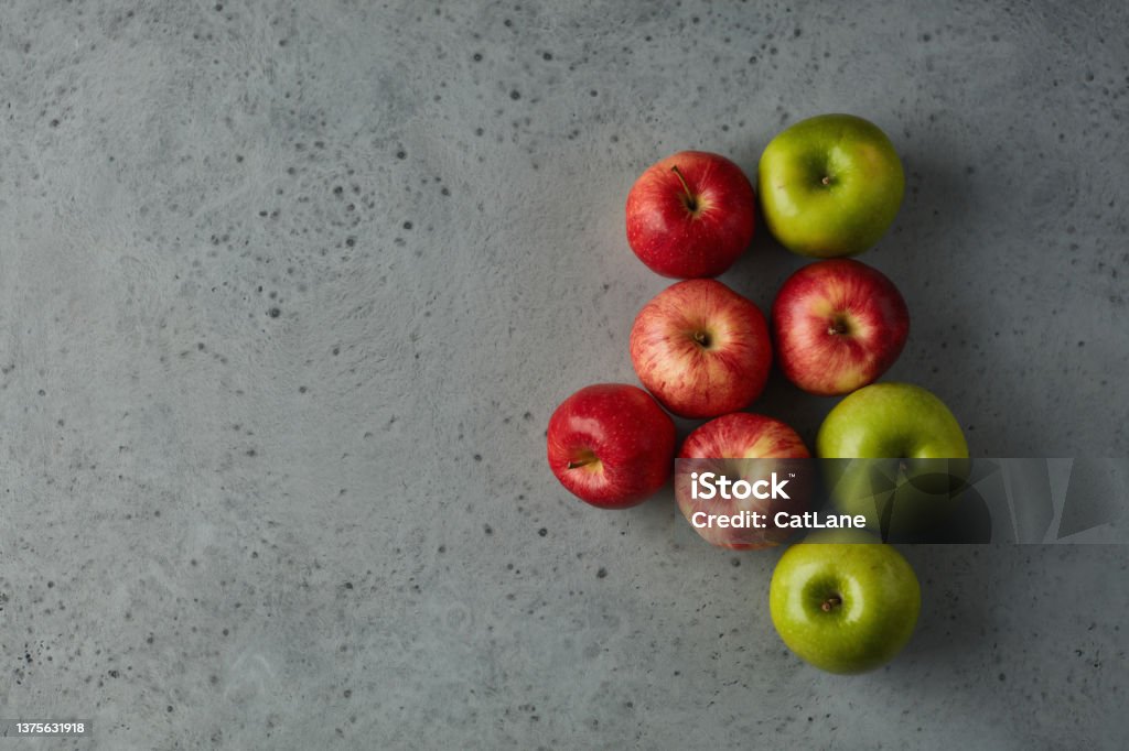 Still life with red and green apples arranged on a gray surface Above Stock Photo