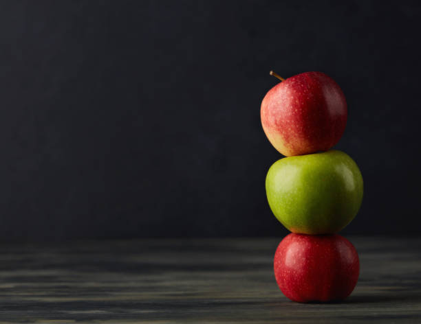 暗い素朴なテーブルの上にリンゴを積み重ねた静物 - apple gala apple fuji apple fruit ストックフォトと画像