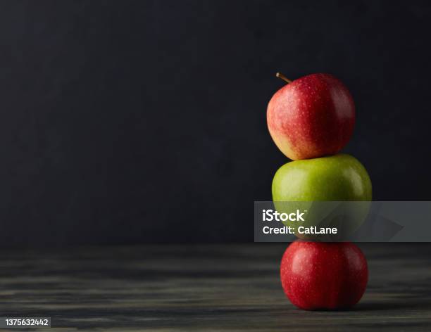Still Life With Apples Stacked Together On A Dark Rustic Table Stock Photo - Download Image Now