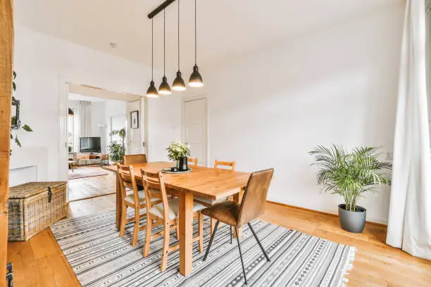 Lovely dining room with wooden table and hanging chandelier