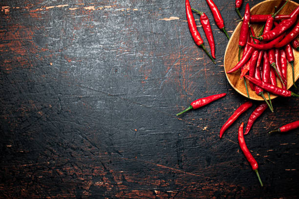 istock Wooden plate with hot chili peppers. 1375643451