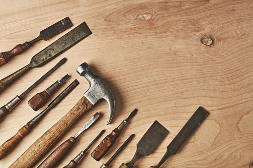 Vintage and antique tools on a pine table with space for text