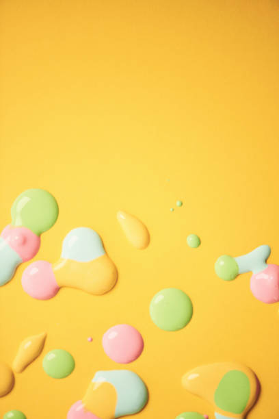 Yellow abstract background with splats of pastel colored paint