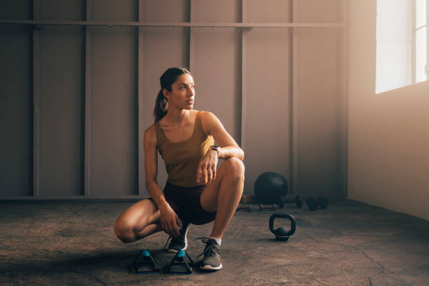 istock Confident Sportswoman Squatting next to Pushup Bars and Looking away 1375659758