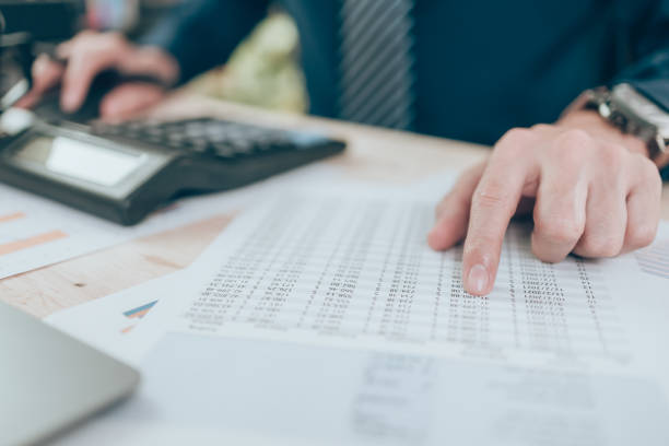 istock Accountant finger point to number on company data, document or report on desk office. Accounting business concept. 1375694330
