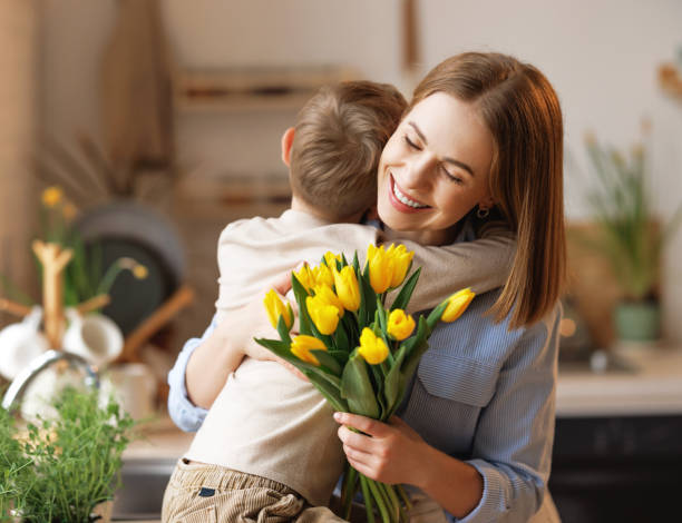 istock Grateful mother with bouquet hugging son 1375708475