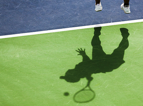 Shadow of tennis player serving