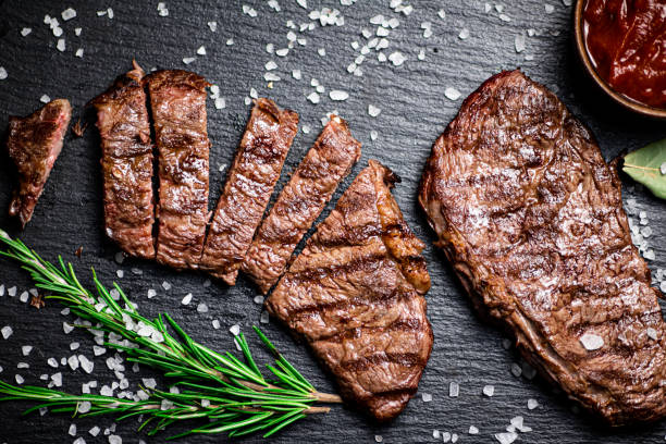 grilled steak with a sprig of rosemary. - top sirloin imagens e fotografias de stock