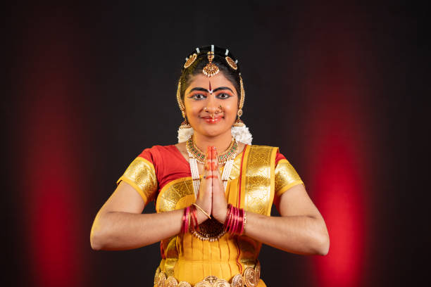 Indian bharatanatyam dancer greeting by doing namaste by looking at camera - concept of traditional confident artist, classical dance and hobbyist. Indian Bharatanatyam dancer greeting by doing namaste by looking at camera - concept of traditional confident artist, classical dance and hobbyist hobbyist stock pictures, royalty-free photos & images