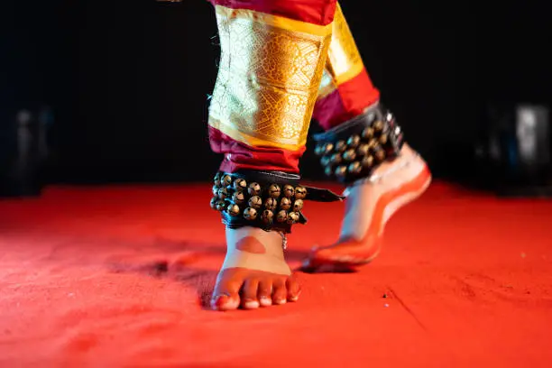 Photo of Close up shot of indian bharatanatyam dancer feet with ghungroo kathak or musical anklet dancing on stage - concept of Indian culture, classical dance and traditions