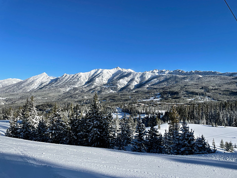 View of trees and snow covered slopes at Big Sky Ski Resort in Montana