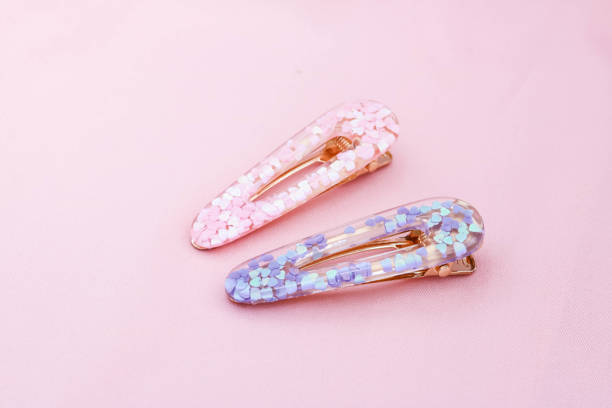 istock Purple and pink hair clips on pink background. 1375795114