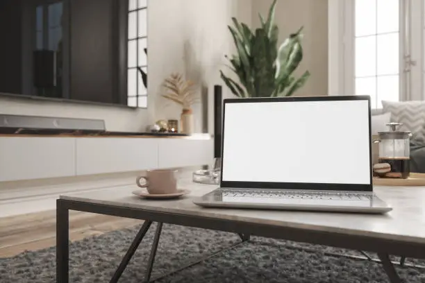 Photo of Working At Home. Laptop With Blank Screen On Coffee Table With Living Room Background.