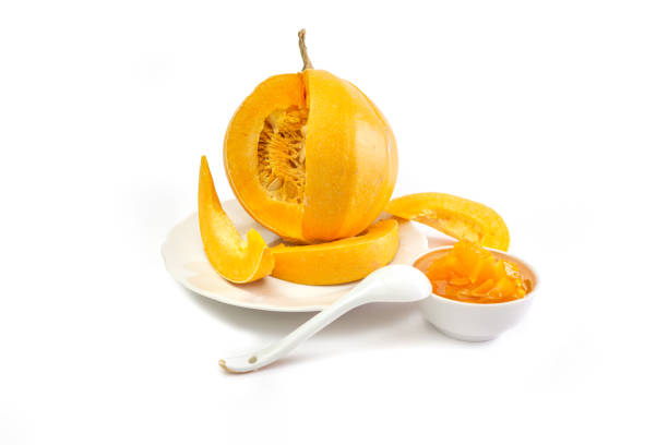 istock Cup with pumpkin jam and pumpkin with slices of pulp on a white background. 1375850974
