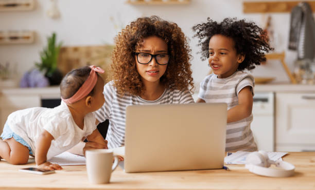 istock Young irritated African-American mother freelancer trying to work while working remotely with kids 1375859305