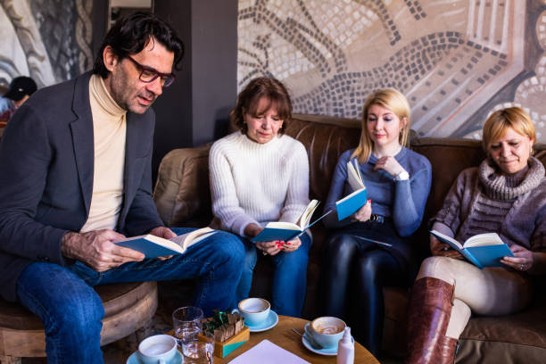 A mature man reading to his book club members