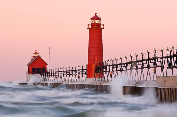 Dawn, Grand Haven Lighthouse Dawn, Grand Haven, Michigan Lighthouse with splashing waves, Lake Michigan, USA Michigan stock pictures, royalty-free photos & images