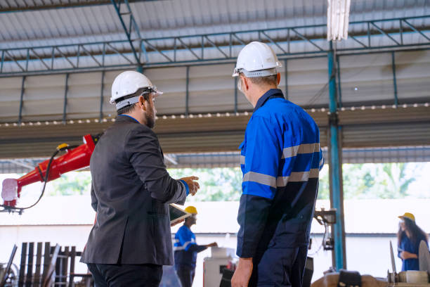 istock Employees are working at factory with robotic arms. 1375877795