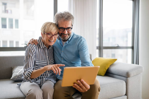 istock Happy smiling mature couple using digital tablet at home 1375878357