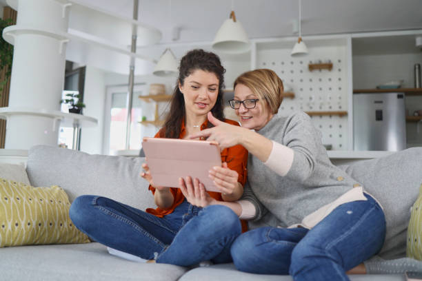 istock Mother and daughter using tablet at home 1375890537