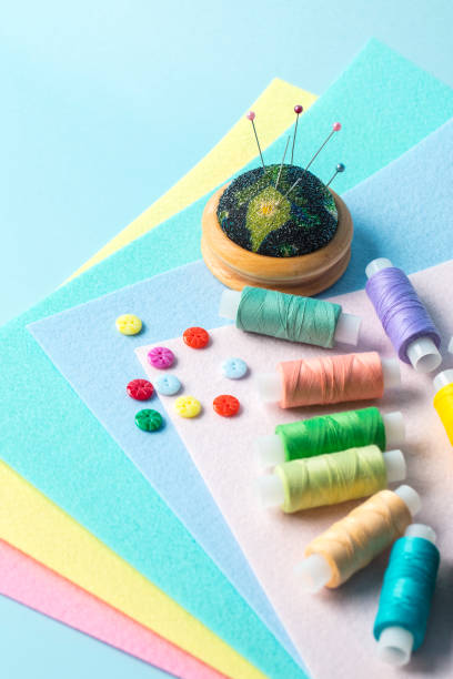 istock Reels of thread with buttons and needles on felt close-up 1375898111