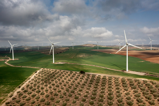 Horizontal  aerial view of Andalusian country and farm landscape with many wind turbines generating electricity