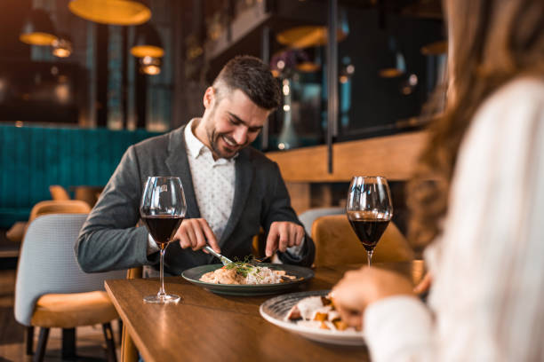 istock Happy man eating lunch with his girlfriend in a restaurant. 1375928760